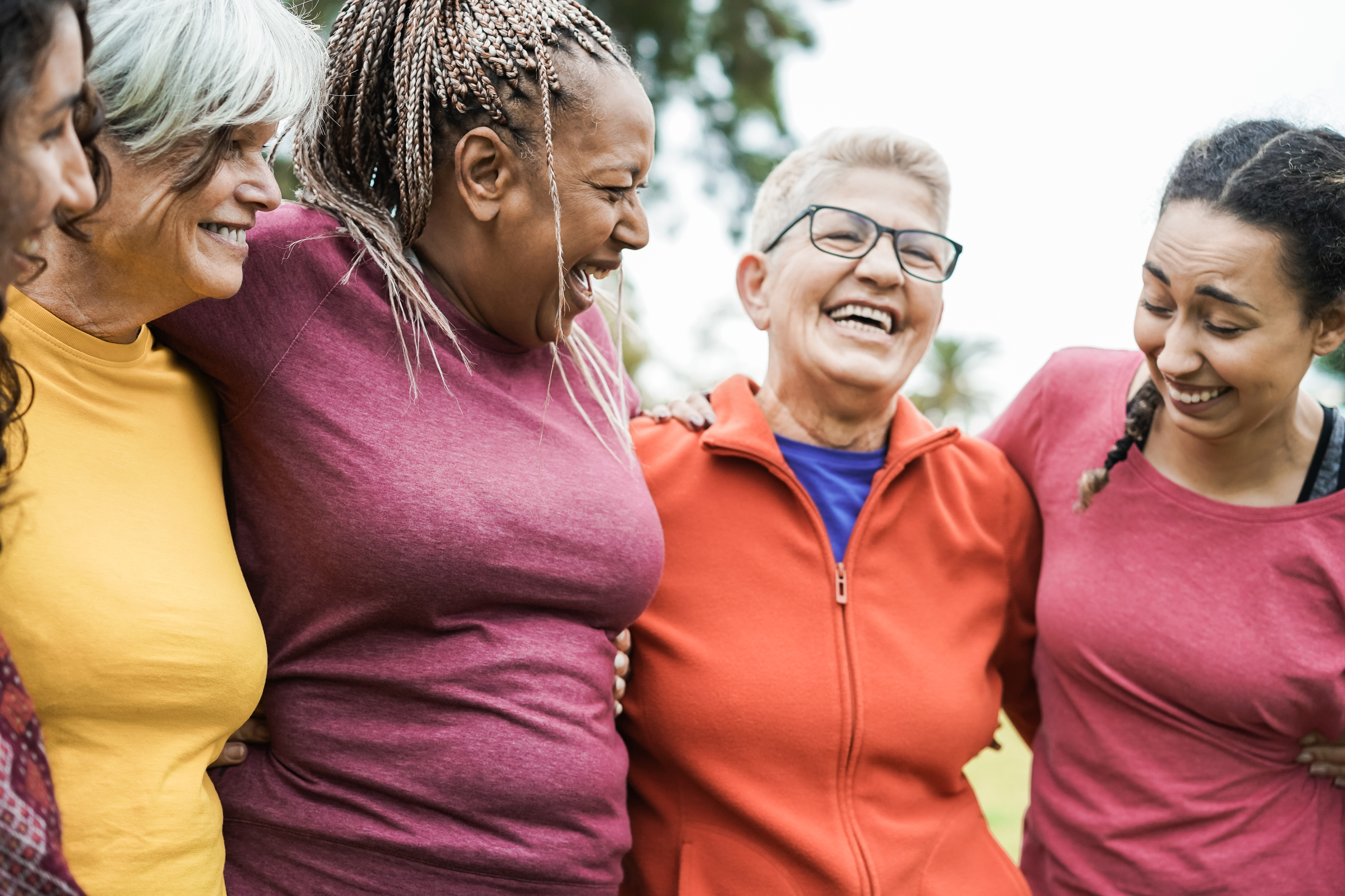 Midlife women smiling together outdoors, representing wellbeing and joint health during menopause